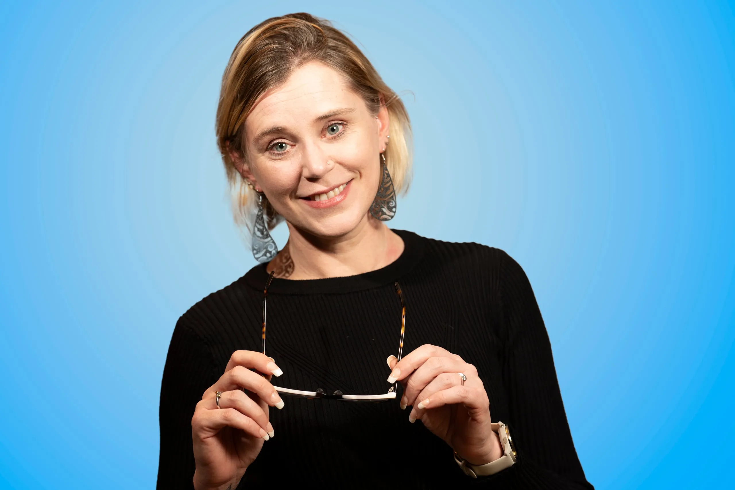 Woman holding glasses in her hands and smiling at the camera