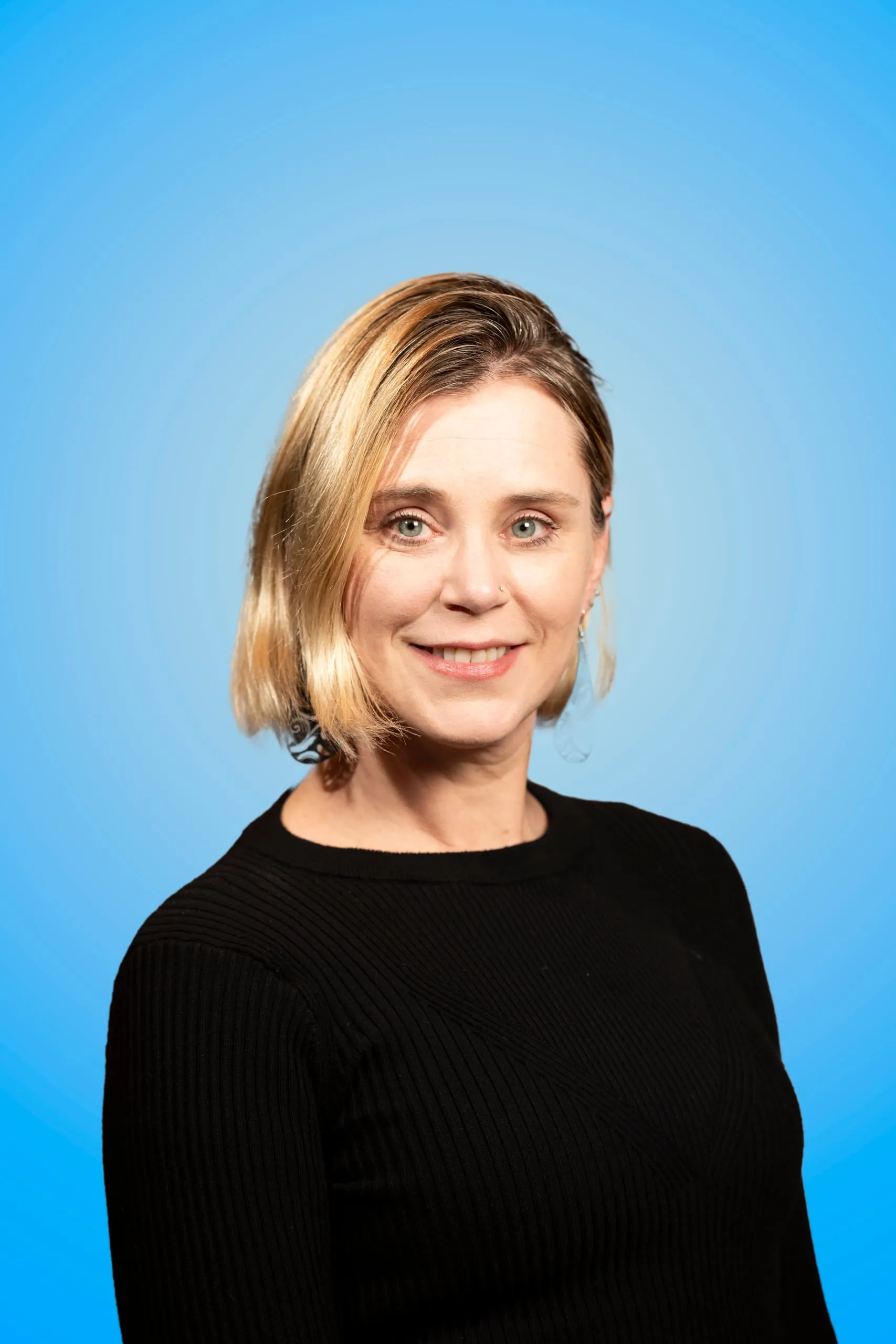 Head-and-shoulders portrait of a smiling woman with short blond hair