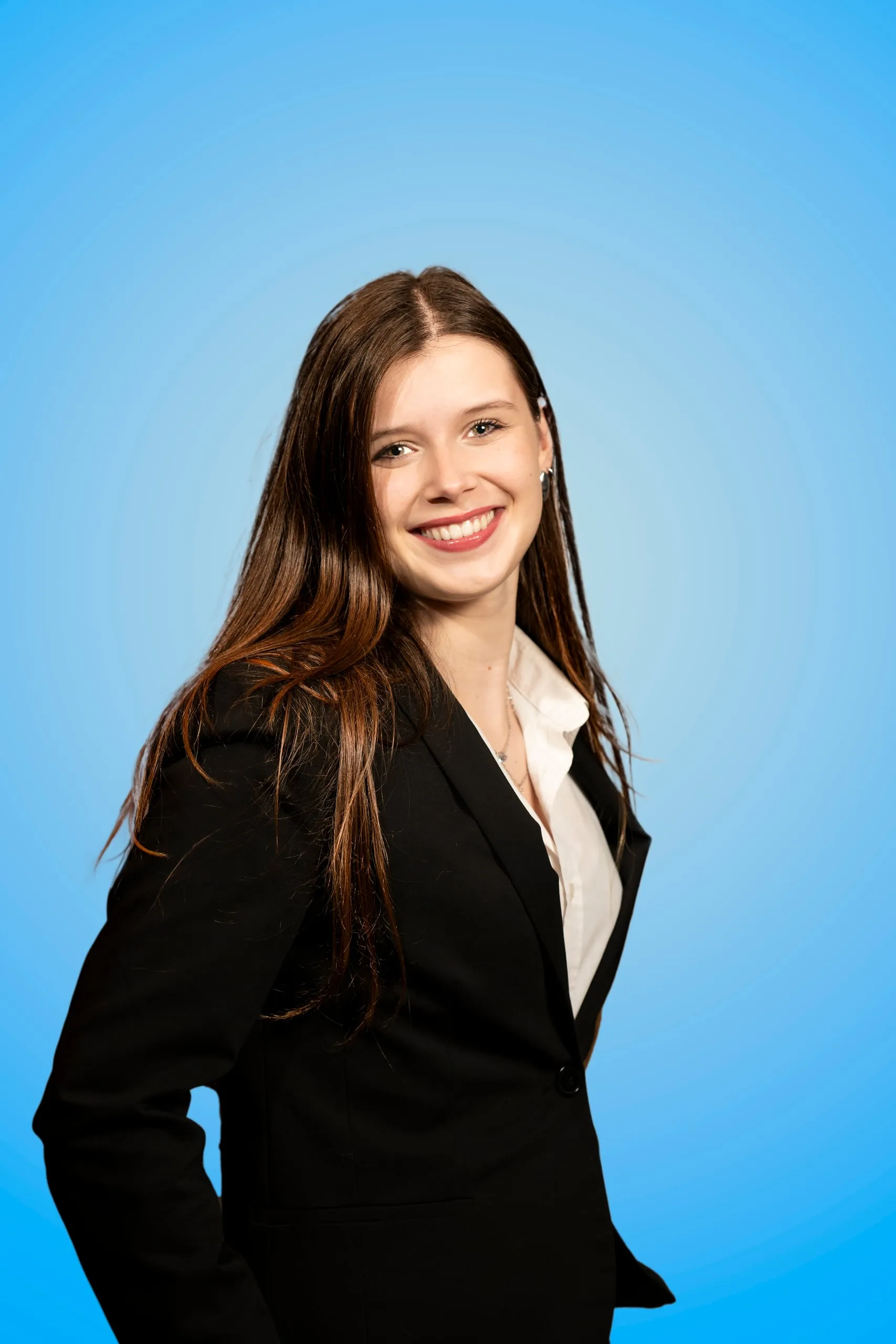 Smiling young woman in a black blazer in three-quarter profile