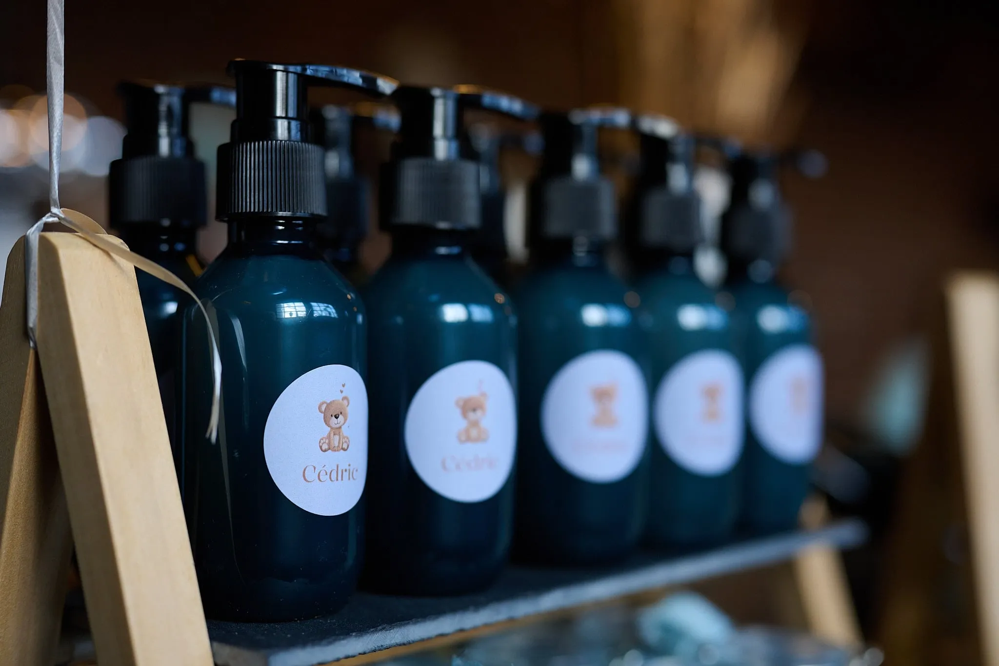 Row of dark pump bottles with a label showing a little teddy bear