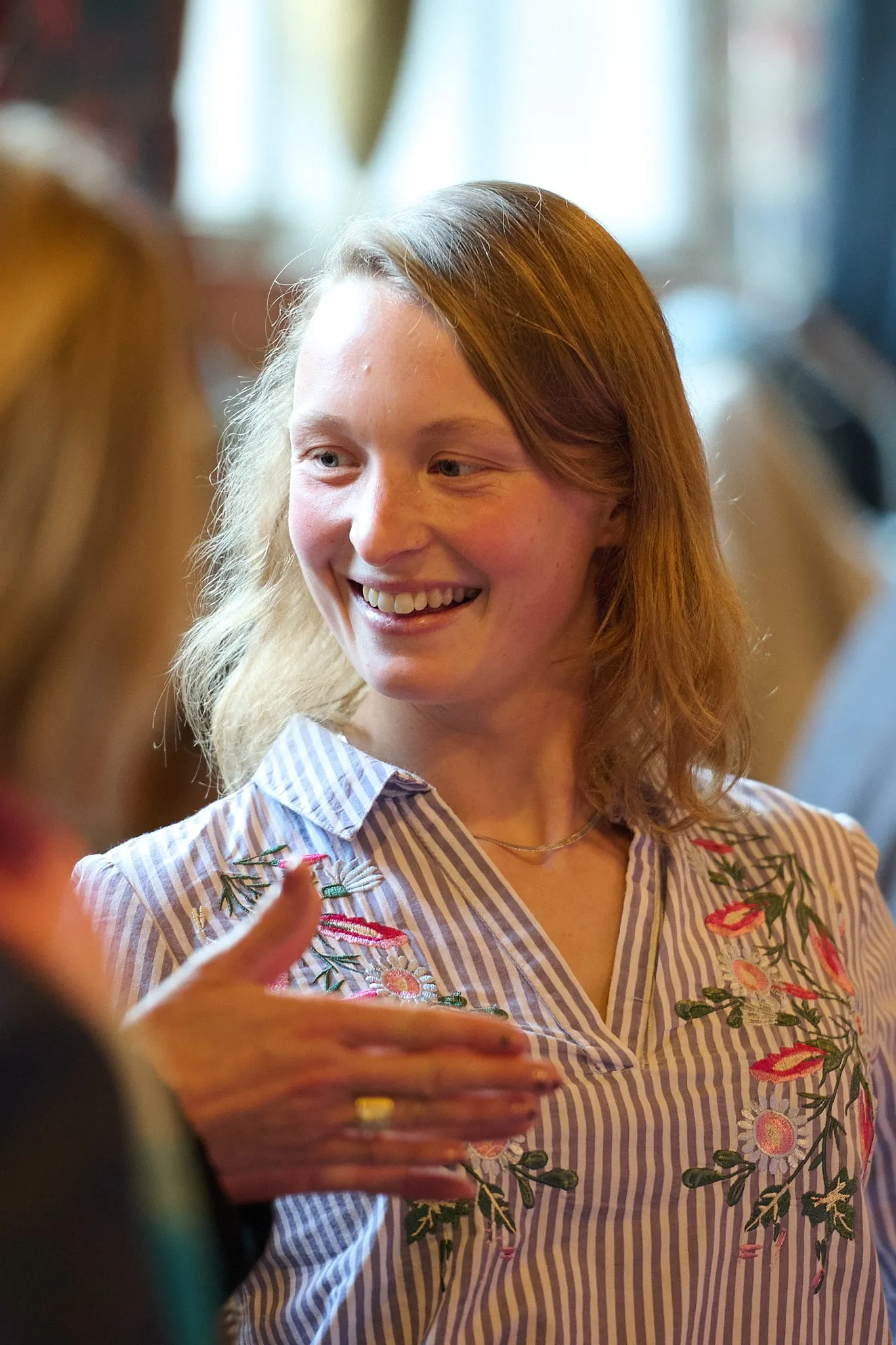 Smiling young woman in a striped blouse in conversation