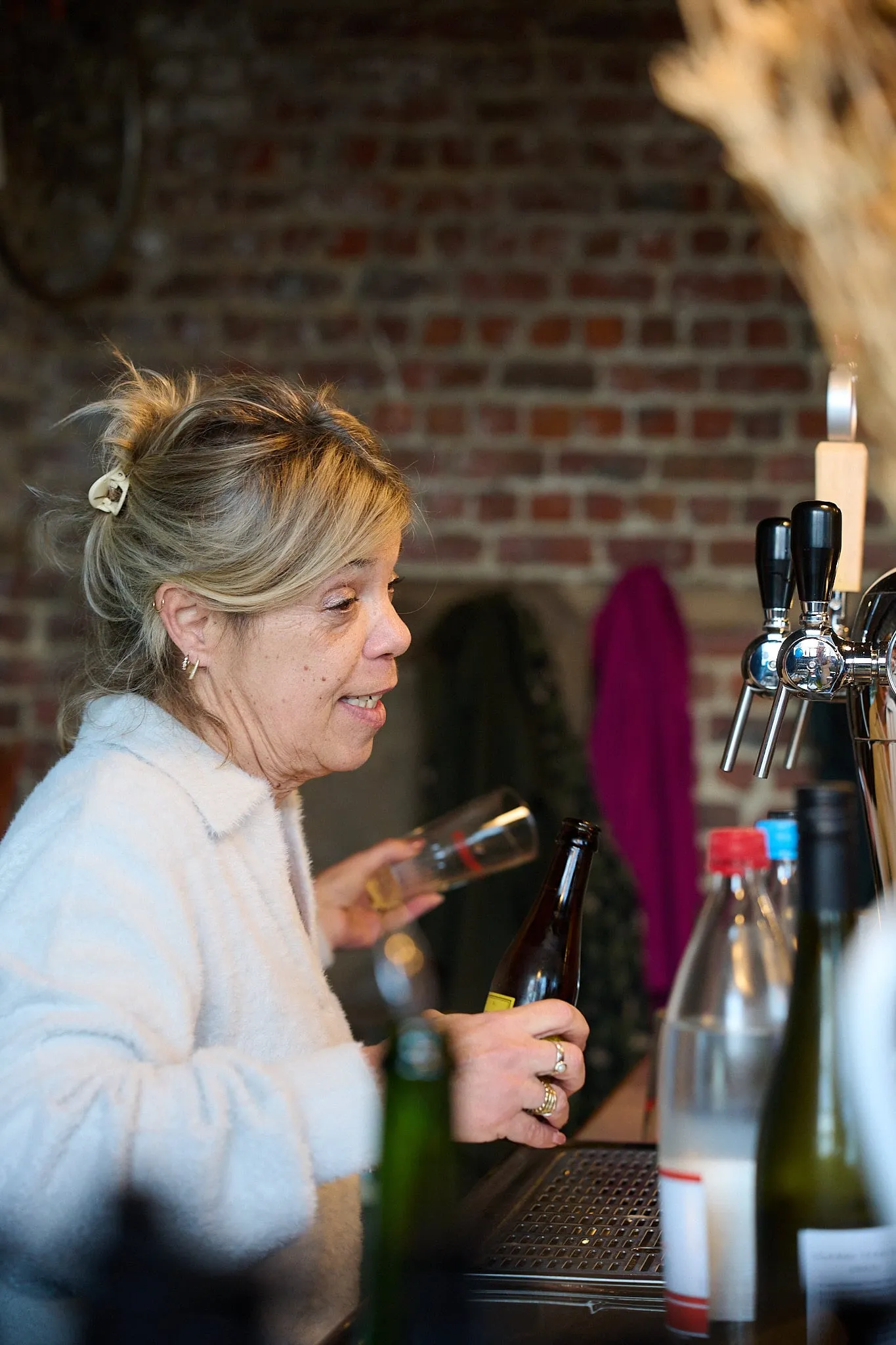 Woman with blond hair pouring a drink at the bar