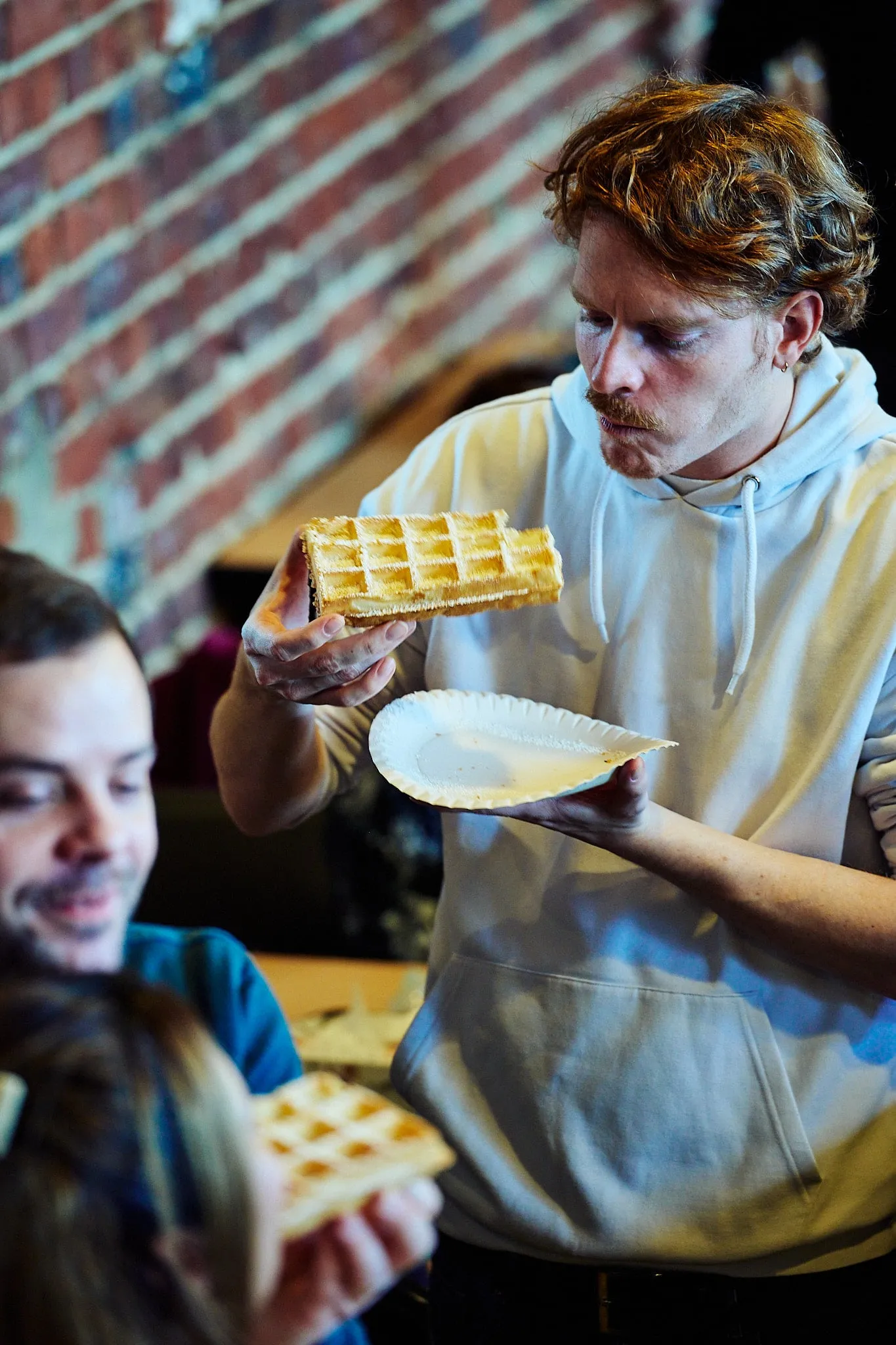 Young man looks at a waffle in his hand