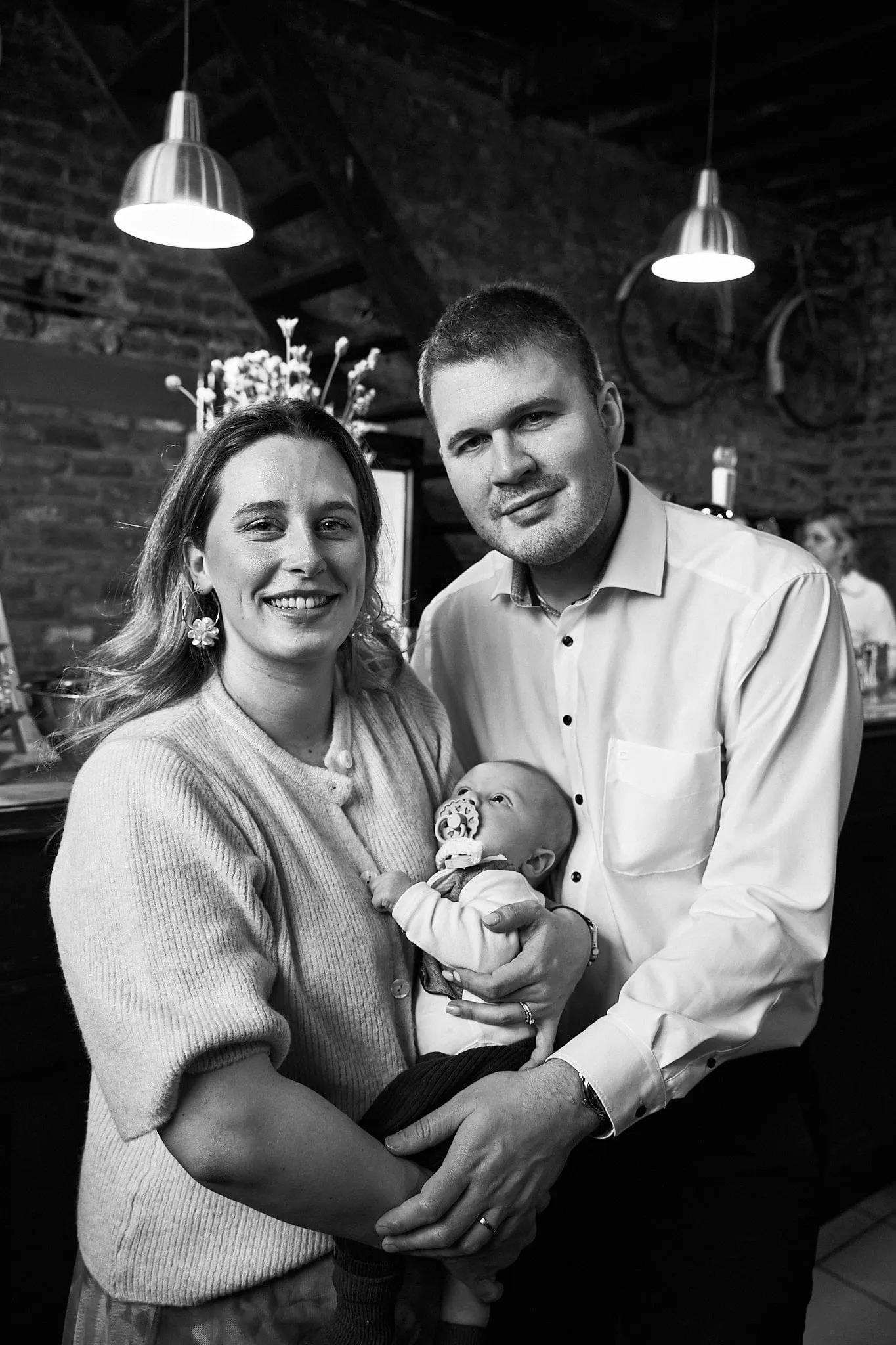 Black-and-white portrait of young parents with their baby