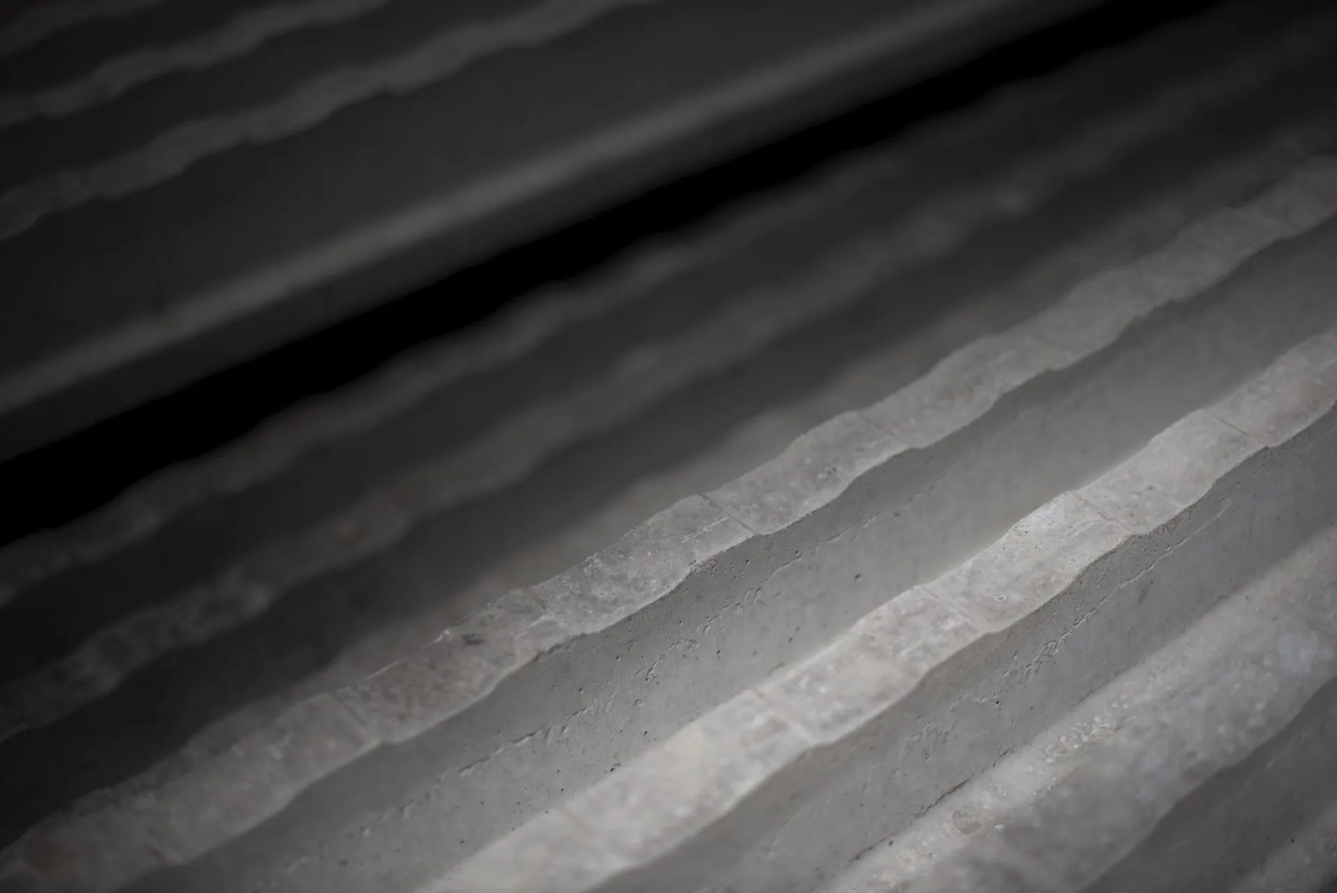 Close-up of wavy concrete steps in black and white, photographed at an angle