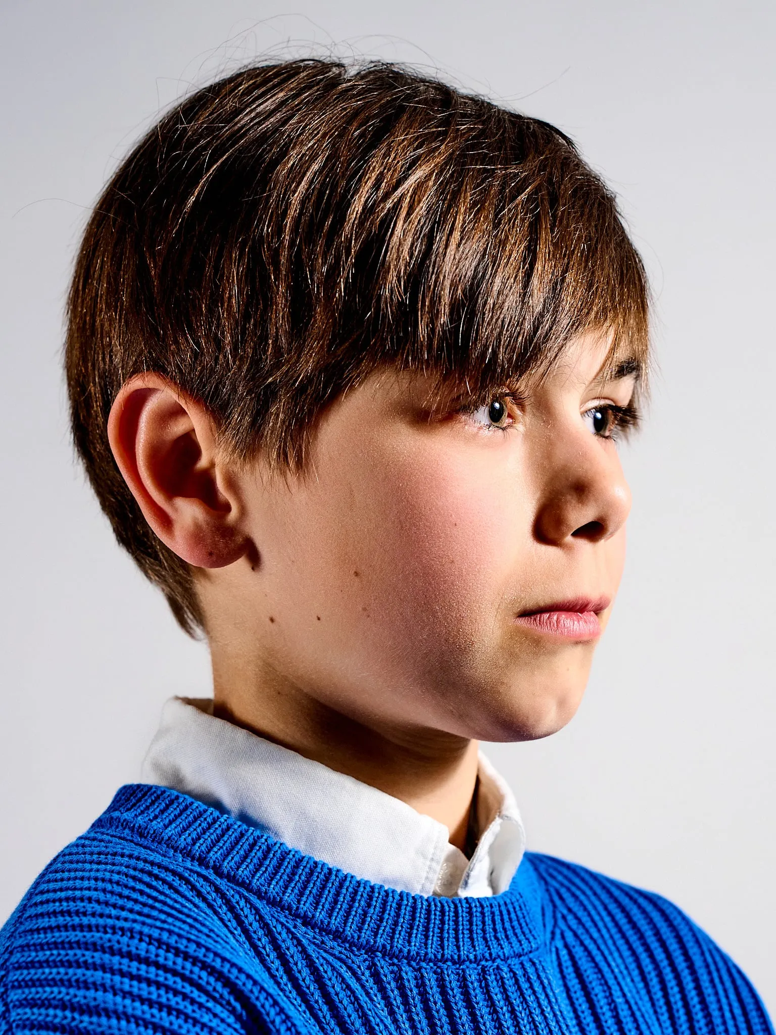 Portrait of a boy in a blue sweater looking aside