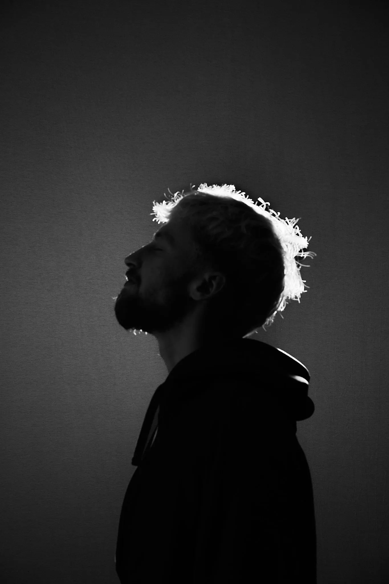 Profile with the head tilted back and rim light on the hair, in black and white