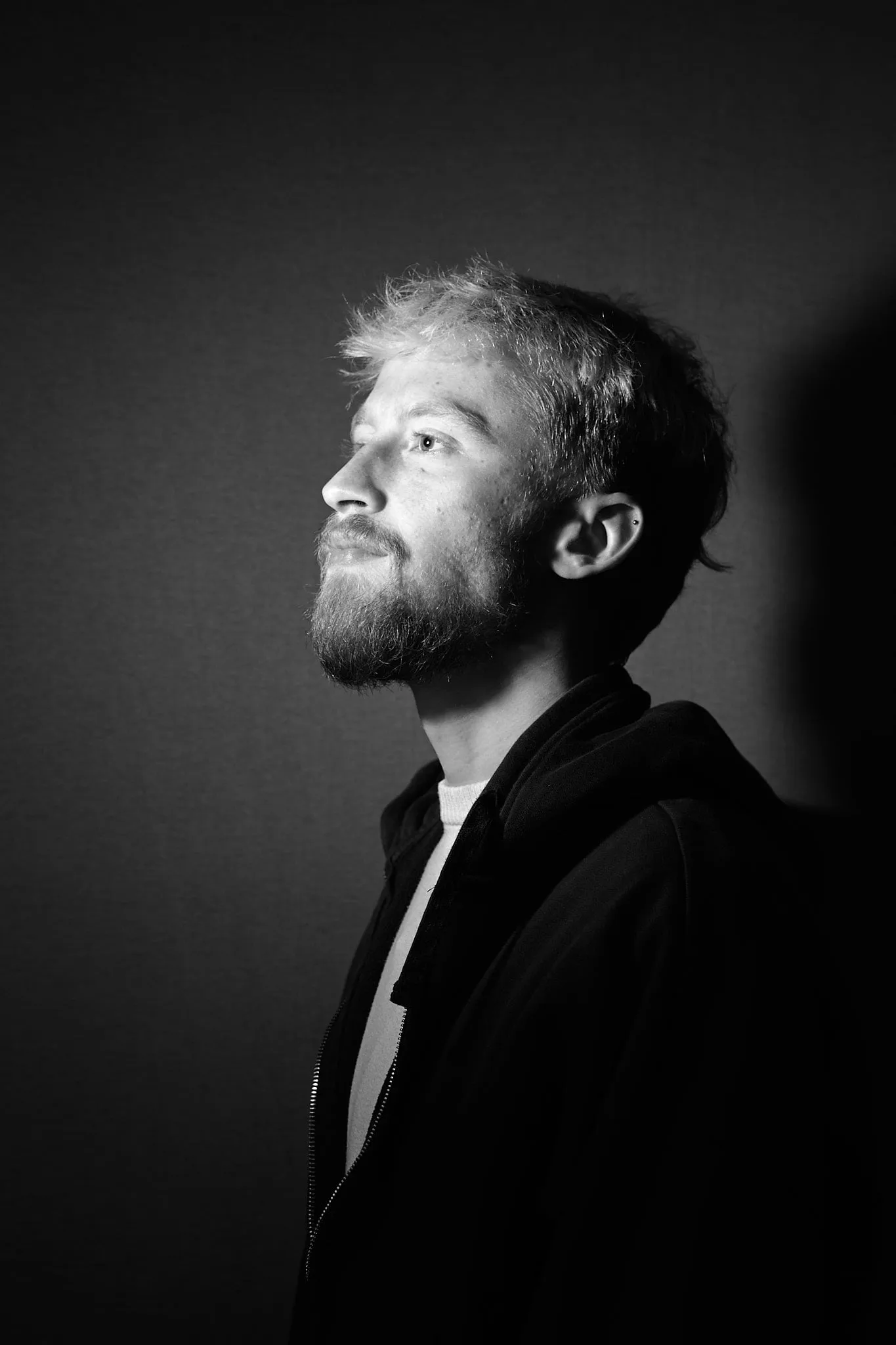 Profile portrait of a bearded man in side light, in black and white