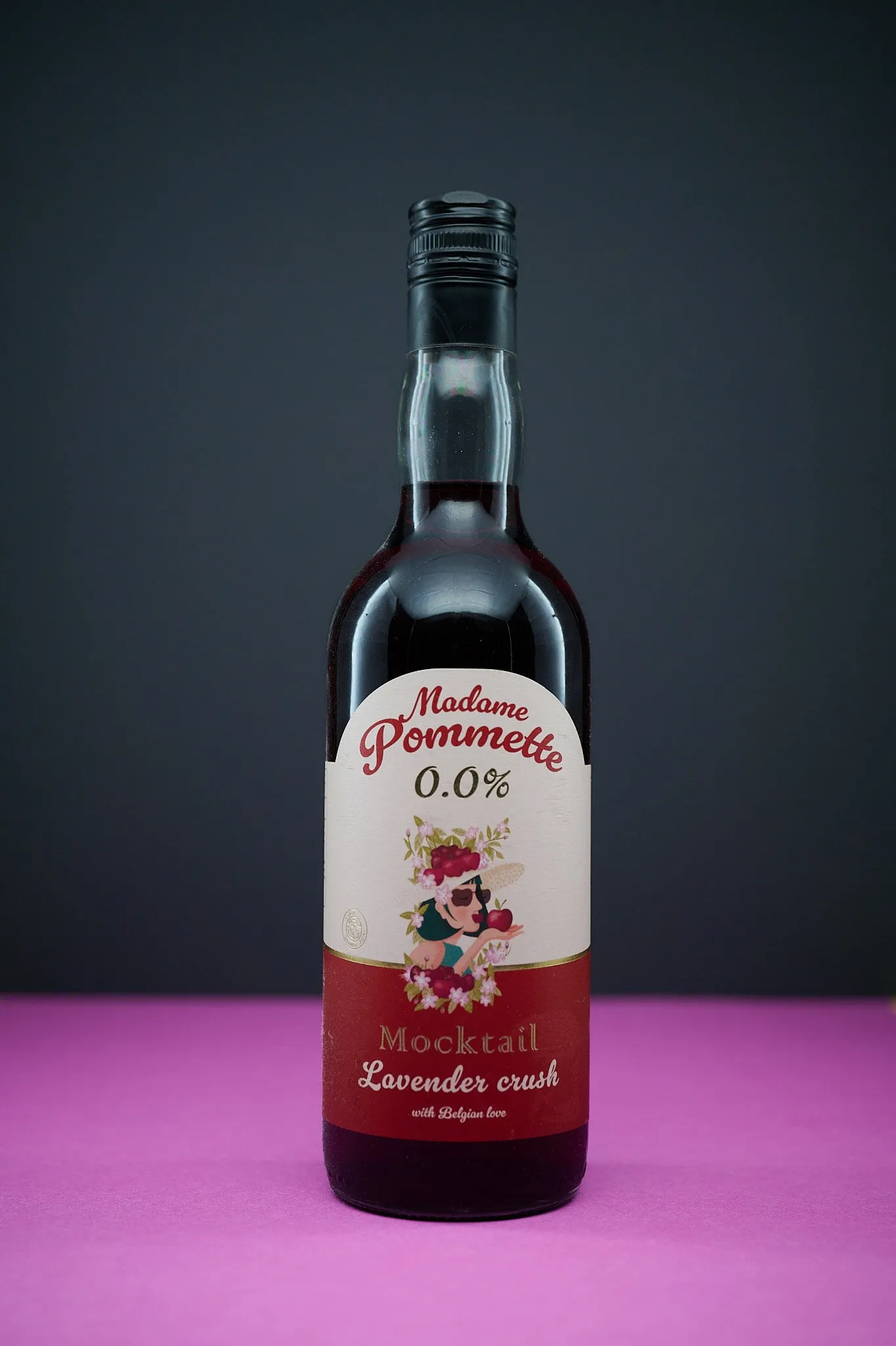 Bottle of Madame Pommette Lavender Crush mocktail on a pink surface