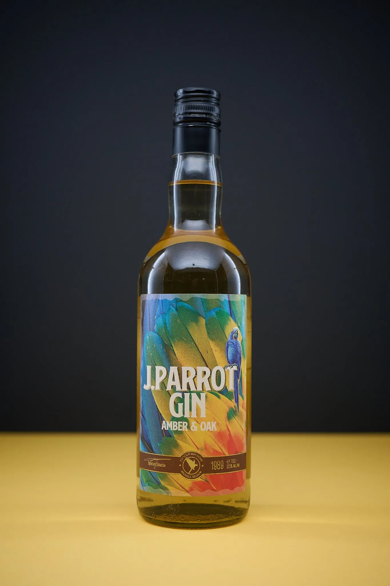 Bottle of J. Parrot Gin Amber & Oak on a yellow surface