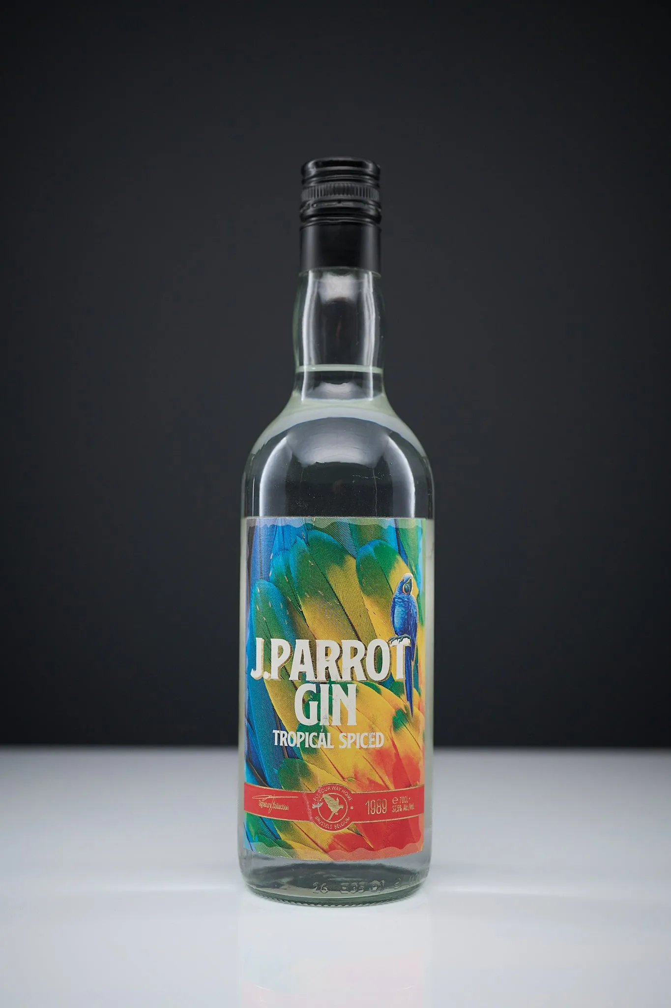 Bottle of J. Parrot Gin Tropical Spiced against a dark background