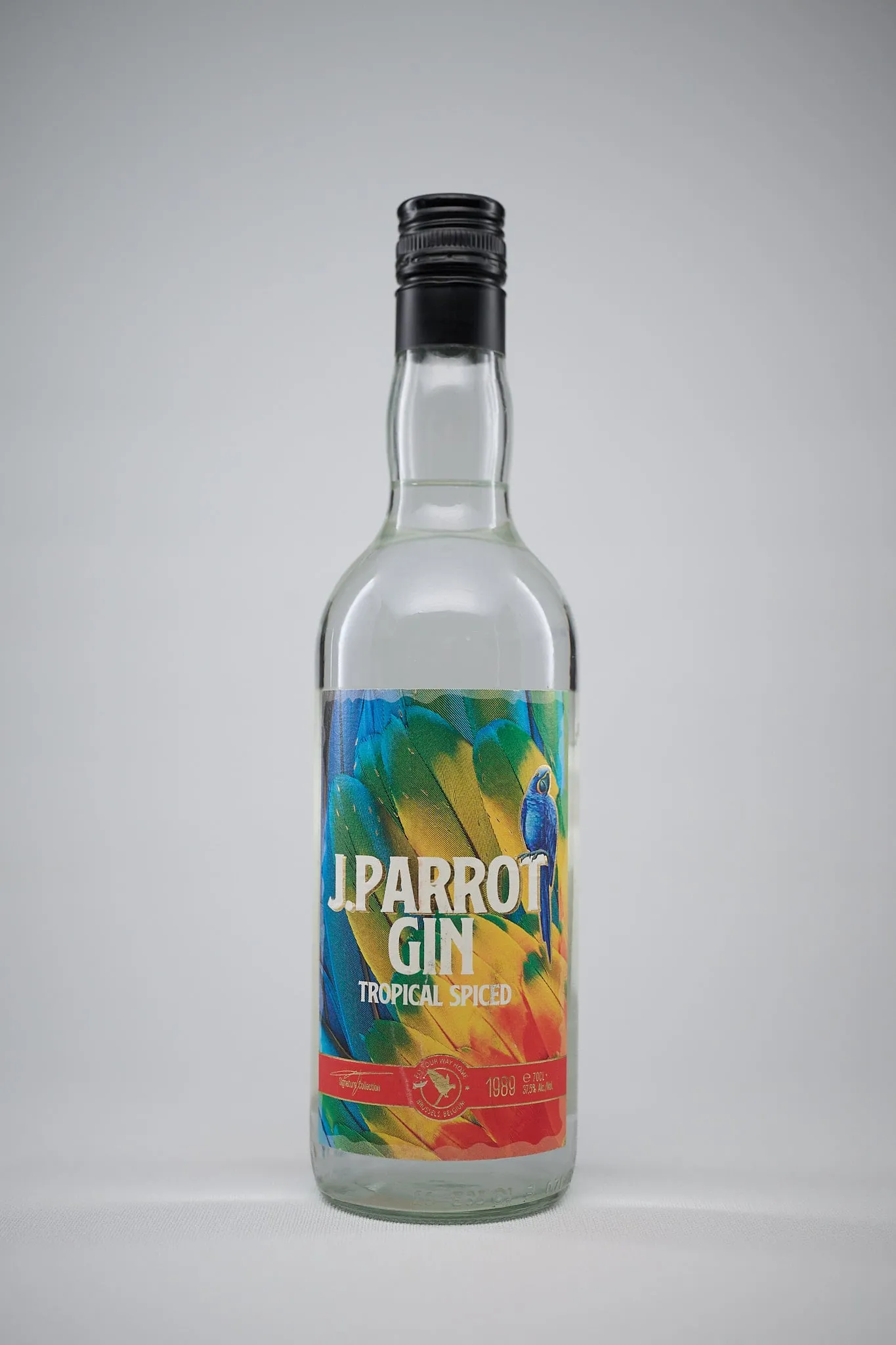 Bottle of J. Parrot Gin Tropical Spiced against a light grey background