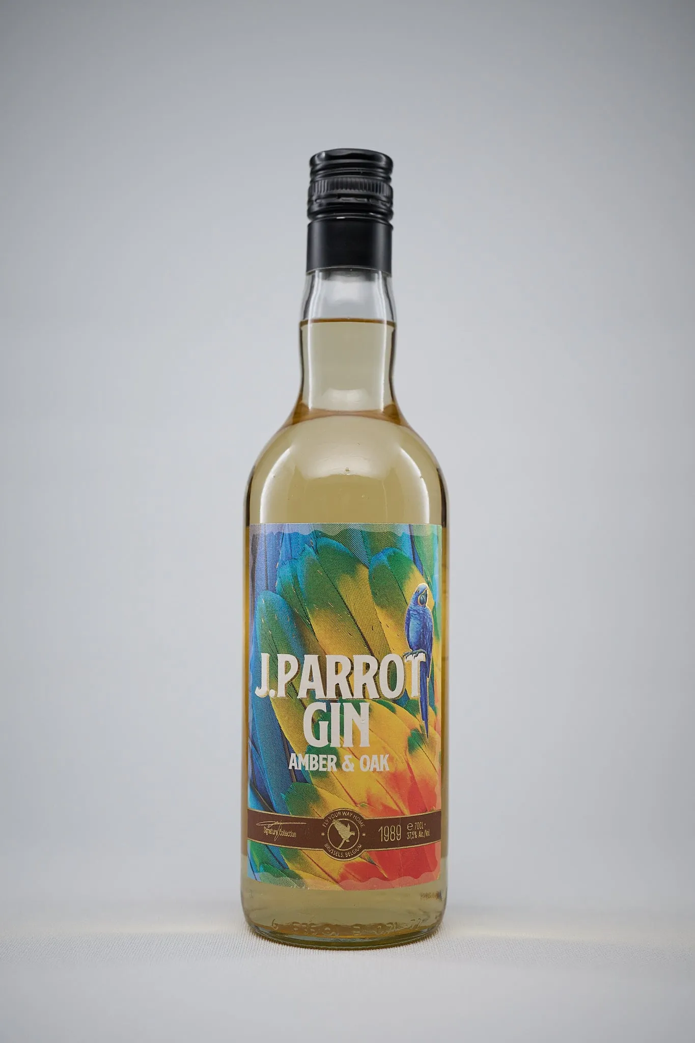 Bottle of J. Parrot Gin Amber & Oak against a light grey background